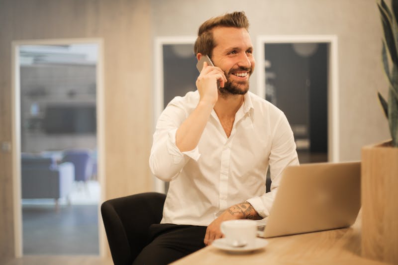 Professional using smartphone for business calls in a modern workspace